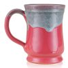 The back of the Bones Coffee Company Soufflé Symphony hand thrown mug. It is cosmo pink colored and has a teal and white glaze on top of it.
