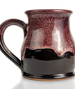 The back of the Dragon’s Lair hand thrown mug. It is black colored with a burgundy and white glaze on top.