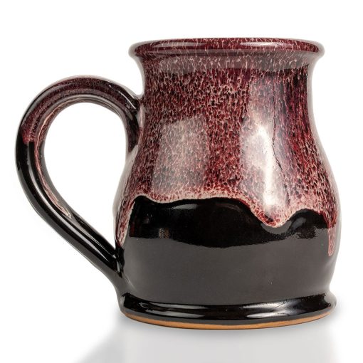 The back of the Dragon’s Lair hand thrown mug. It is black colored with a burgundy and white glaze on top.