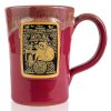 The front of the Bones Coffee Company Santa Jack hand thrown mug with Jack Skellington dressed as santa on the golden medallion. The mug is cranberry colored with a white glaze on top.