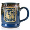 The front of the Bones Coffee Company S’morey Time Handthrown Mug. It has the S’morey Time art on the golden medallion. The mug is blue colored with a cinnamon and white glaze.