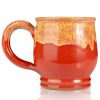 The back of the Twin Sun Tiramisu hand thrown mug. It is paprika colored with a yellow glaze on top.