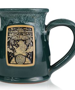 The front of the Bones Coffee Company Frog’s Breath hand thrown mug with Sally from Tim Burton’s The Nightmare Before Christmas on the golden medallion. The mug is green colored with a white glaze on top.