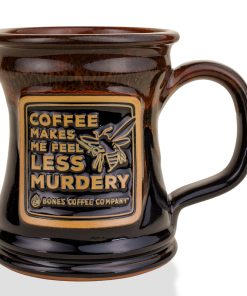 The front of the Bones Coffee Company Murder Hornet Handthrown Mug. It has a hornet with a knife and it says coffee makes me feel less murdery on the golden medallion. The mug is black colored with a sunset orange glaze.