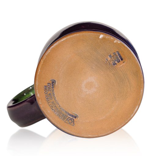The bottom of the Mudslide Boogie hand thrown mug. It says Deneen Pottery on the tan bottom.