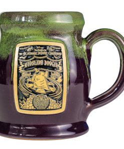 The front of the Bones Coffee Company Mudslide Boogie hand thrown mug with Oogie Boogie from Tim Burton’s The Nightmare Before Christmas on the golden medallion. The mug is plum colored with a kiwi glaze on top.