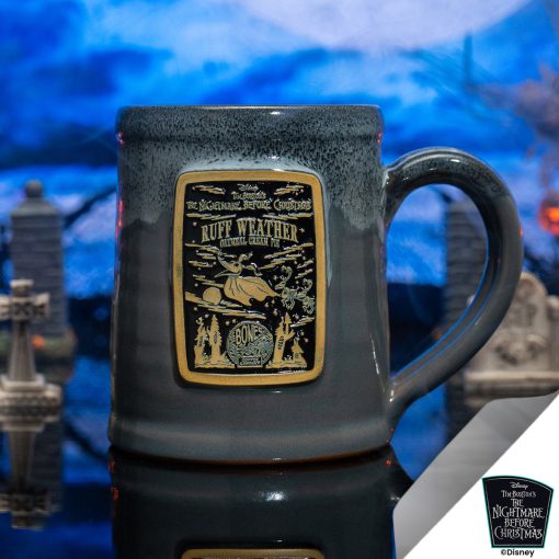 The front of the Bones Coffee Company Ruff Weather hand thrown mug with Zero the dog on the golden medallion. It is inspired by Disney Tim Burton’s The Nightmare Before Christmas. The mug is grey colored with a black and white glaze on top. It is inside a toy graveyard.