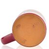 The bottom of the Santa Jack hand thrown mug. It says Deneen Pottery on the tan bottom.