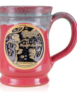 The front of the Bones Coffee Company Soufflé Symphony hand thrown mug with Squidward and Plankton on the golden medallion. It is inspired by SpongeBob SquarePants. The mug is cosmo pink colored and has a teal and white glaze on top of it.