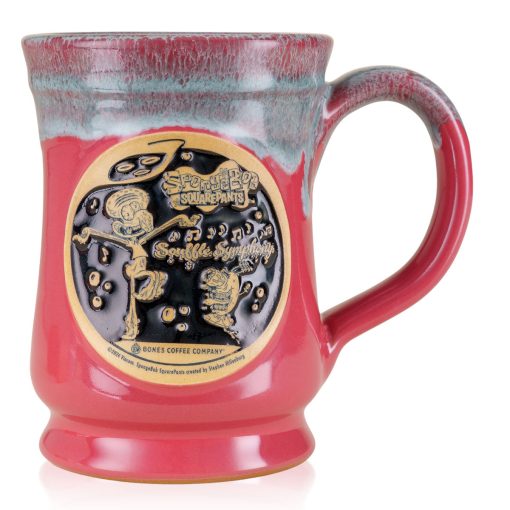 The front of the Bones Coffee Company Soufflé Symphony hand thrown mug with Squidward and Plankton on the golden medallion. It is inspired by SpongeBob SquarePants. The mug is cosmo pink colored and has a teal and white glaze on top of it.